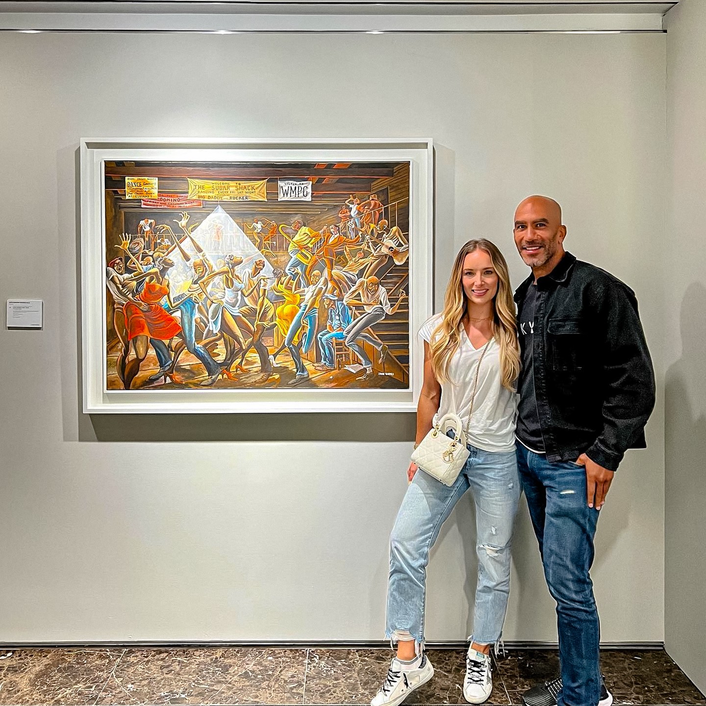 Bill and Lara Perkins standing with the Sugar Shack by Ernie Barnes.